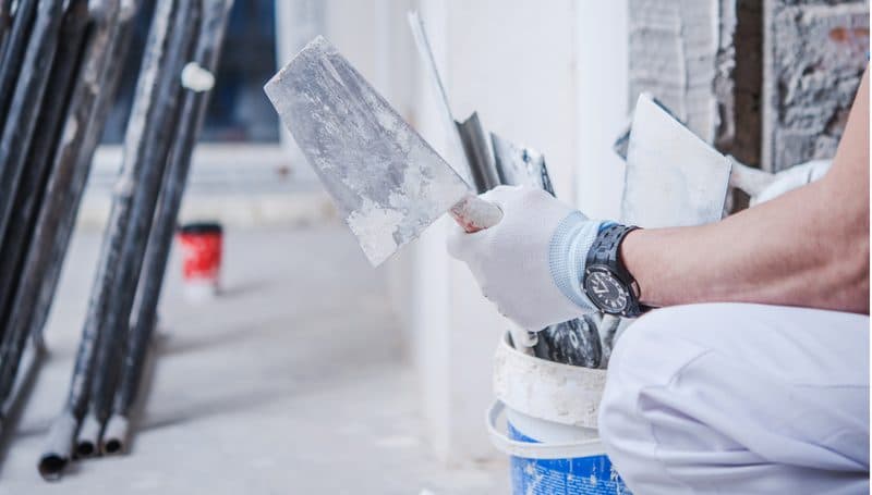 Plasterer holding a trowel on a work site
